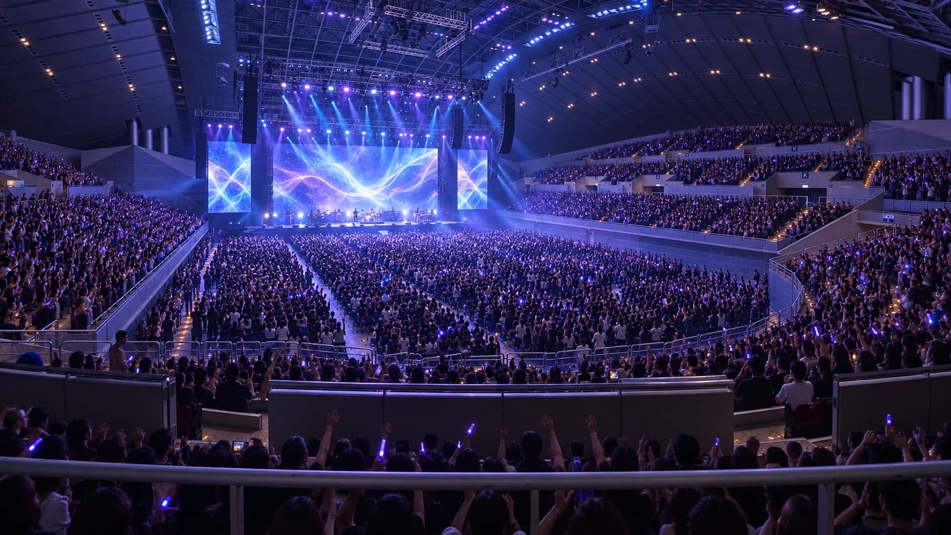 Full arena in Japan mid-show, stage LED and lighting rig running to a standing crowd